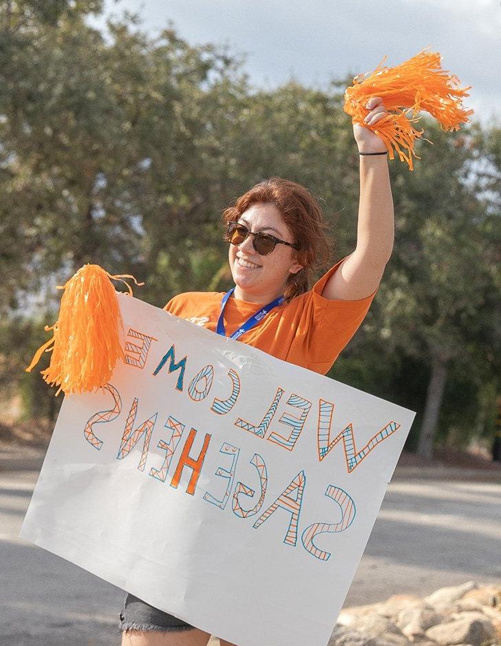 an admission student staff member welcomes new students to campus